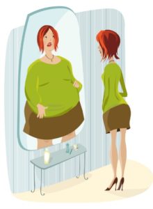 Slim woman sees herself as overweight in mirror